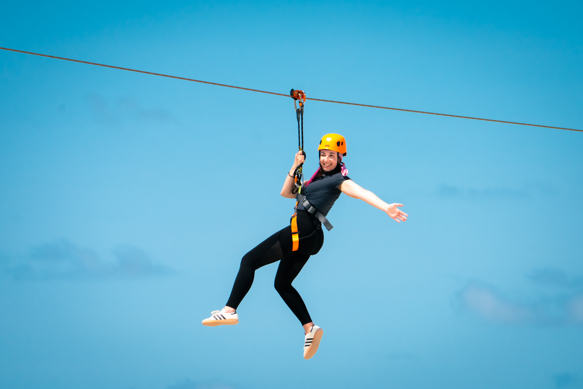 A rider on Zipline Maldives against the turquoise sky